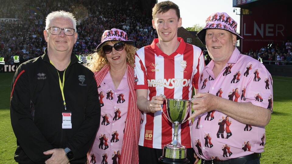 Conor McGrandles is presented a trophy by three people