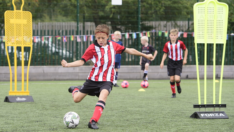 A boy kicks a football