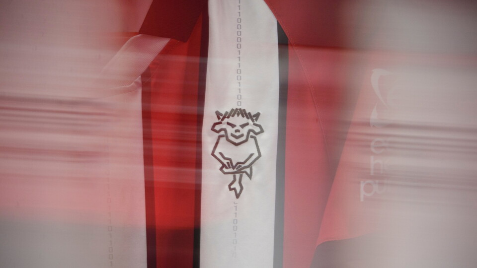 Red and white abstract image featuring an Imps logo in black on a vertical strip. The scene is blurred, conveying a sense of motion and energy.