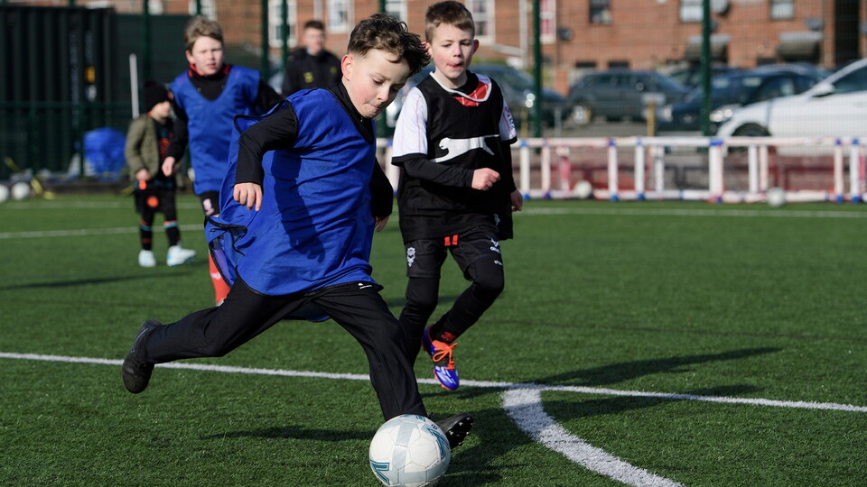 Kids play football as part of the Lincoln City Foundation's holiday club