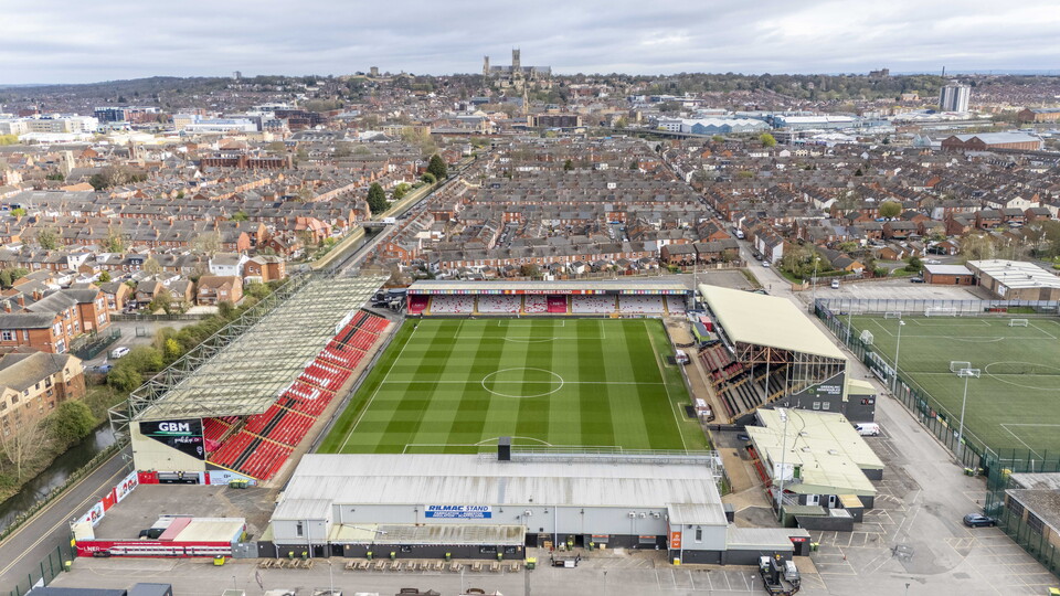 An overhead shot of the LNER Stadium looking towards the city centre. You can see Lincoln Cathedral on the horizon.