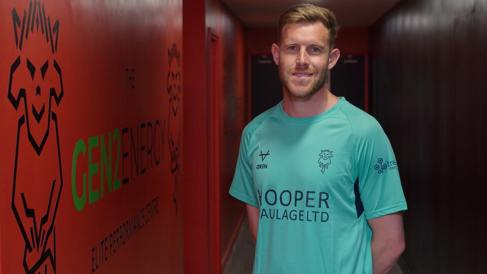 Callum Elder poses, stood in a corridor