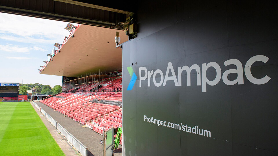 A ProAmpac Stadium sign with a red football stand in the background