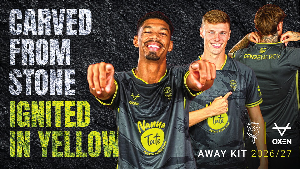 Three male football players wearing dark gray and yellow away kits for 2026/27, posing with text 'Carved from stone, ignited in yellow.'
