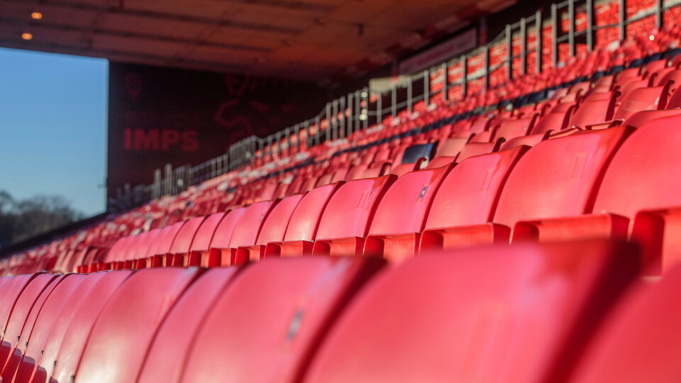 Some red seats in a football stadium.