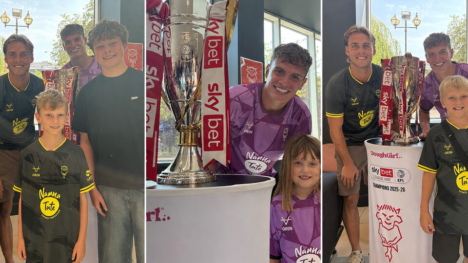 Footballers and children pose for photos with the League One trophy