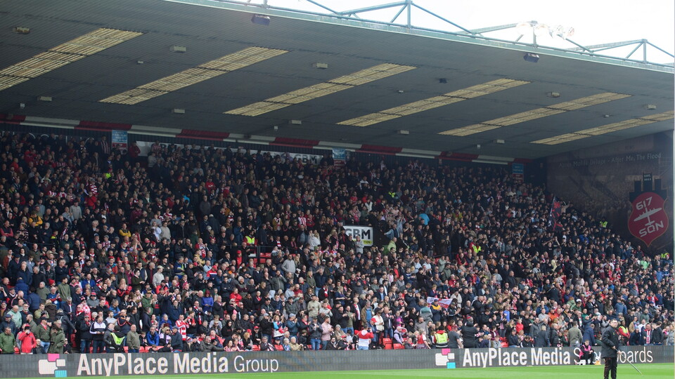 A football stand with supporters in it.
