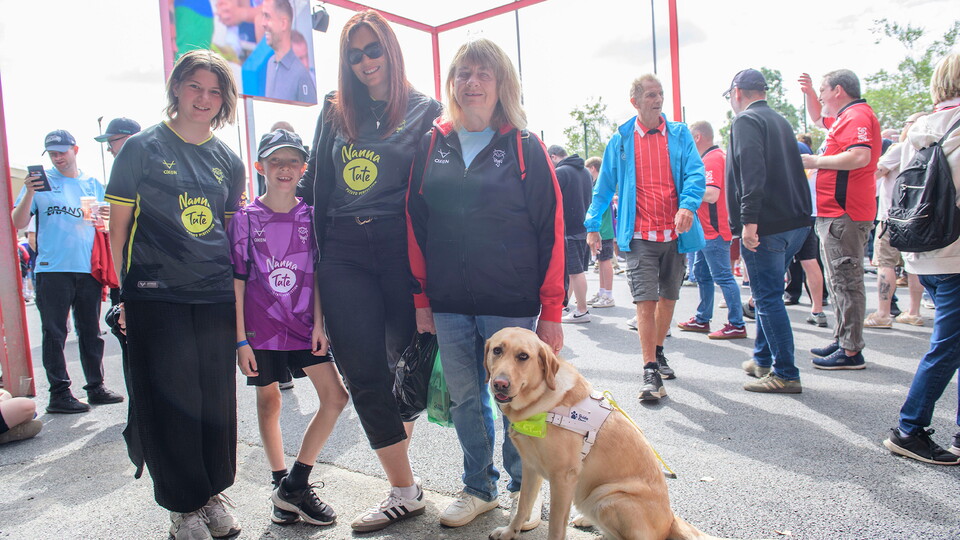 Fans pose for a photo in the Fan Village outside the ProAmpac Stadium
