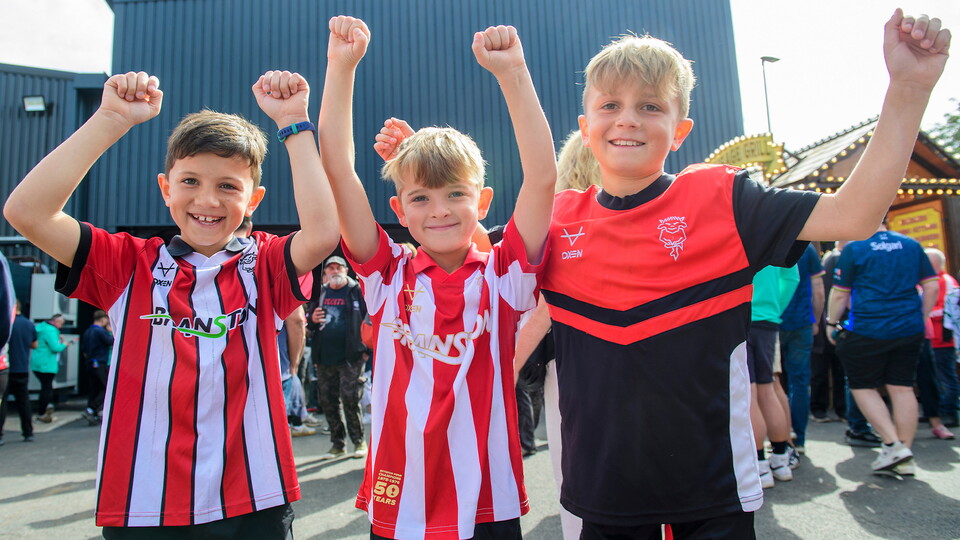 A group of young fans pose for a photo outside of the ProAmpac Stadium