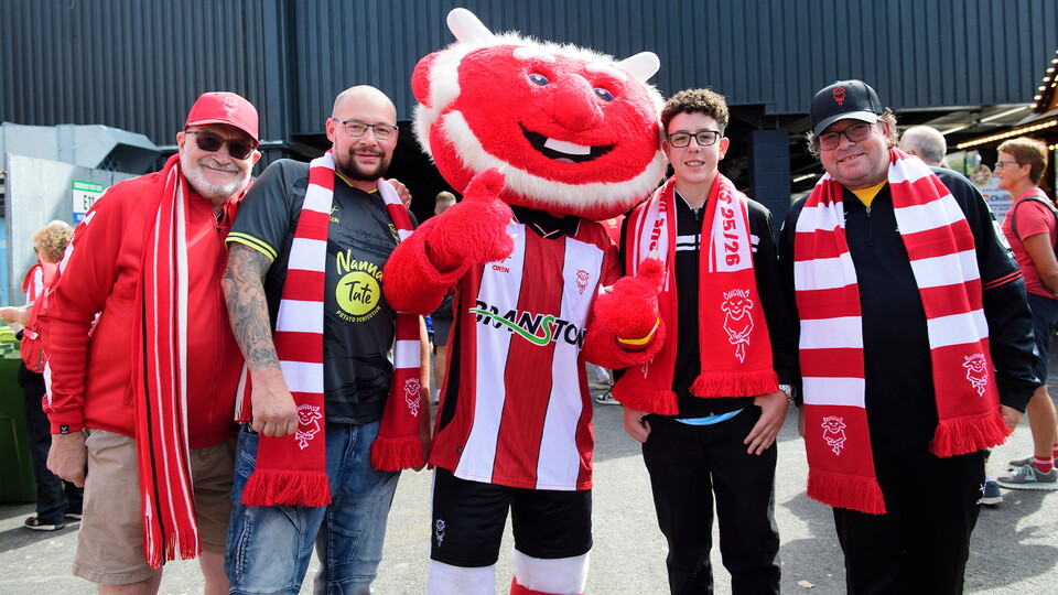 Fans pose for a picture with Poacher the Imp outside the ProAmpac Stadium