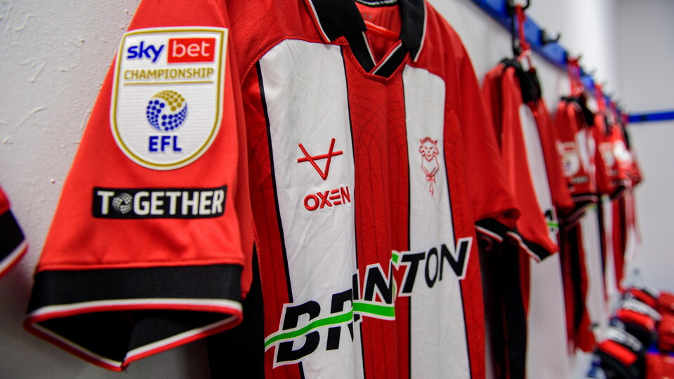 Red and white shirts hung up in a changing room