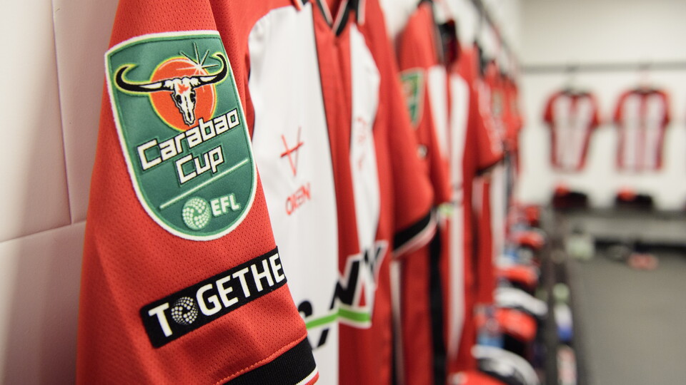 Red and white shirts hung up in a changing room