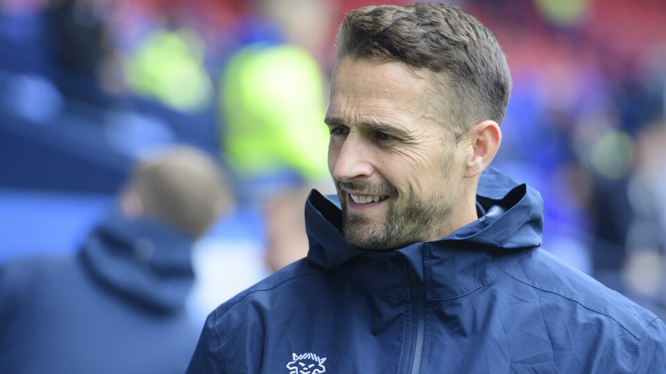 Chris Cohen wearing a blue rain jacket