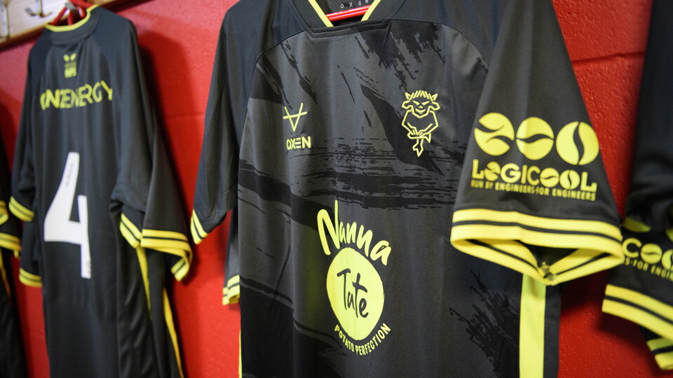 Black shirts hung up in a changing room