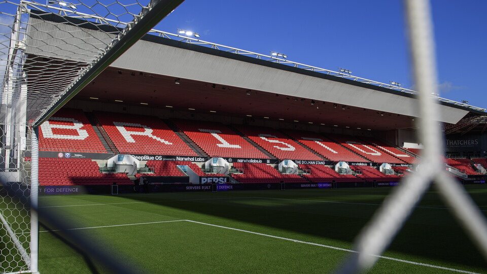 A view of the stadium at Aston Gate. it is a red stand with BRISTOL written in the seats.