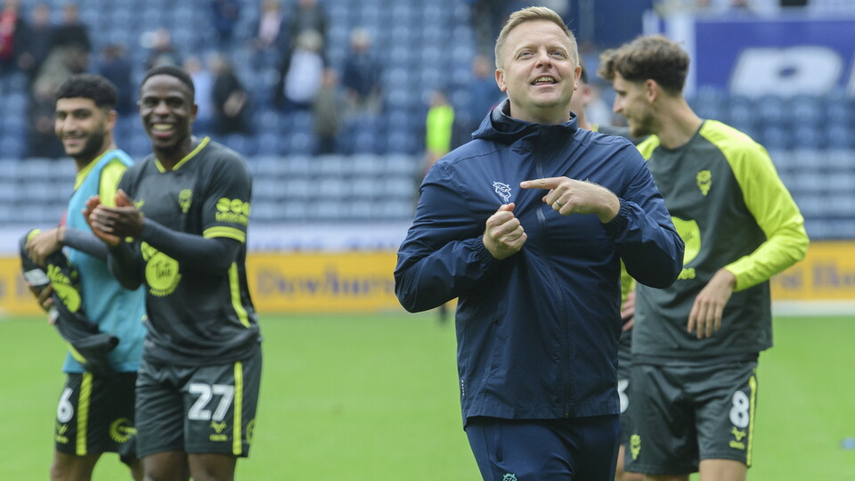 Tom Shaw points to a Lincoln City badge on his jacket