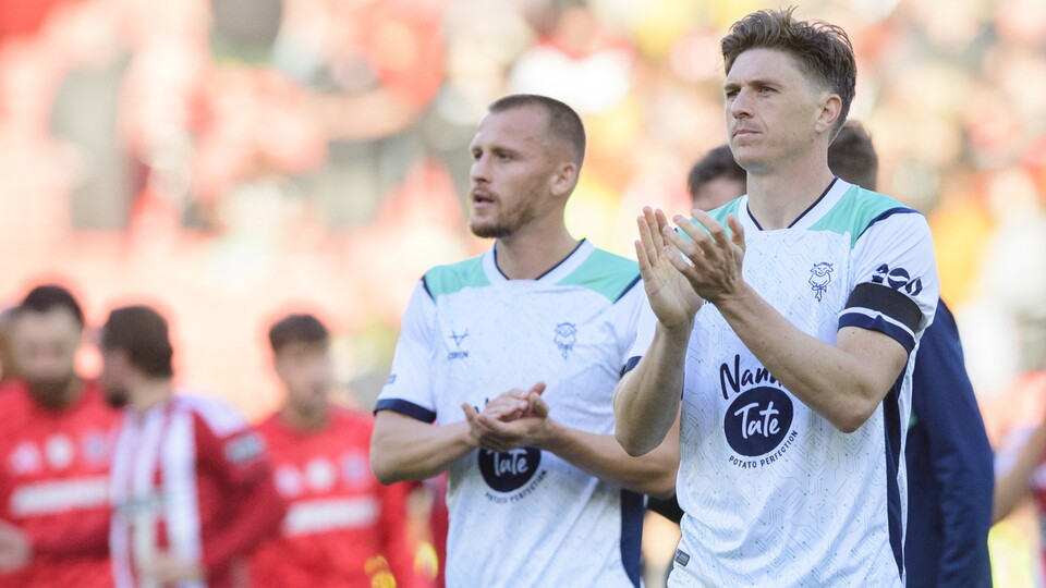 Two men in white shirts applaud