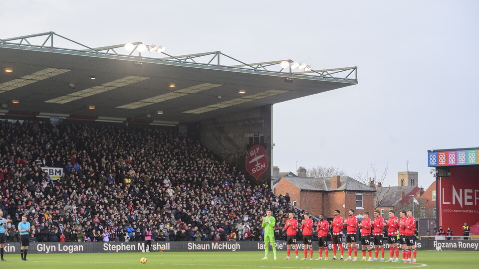Lincoln City players line up for a minute's applause