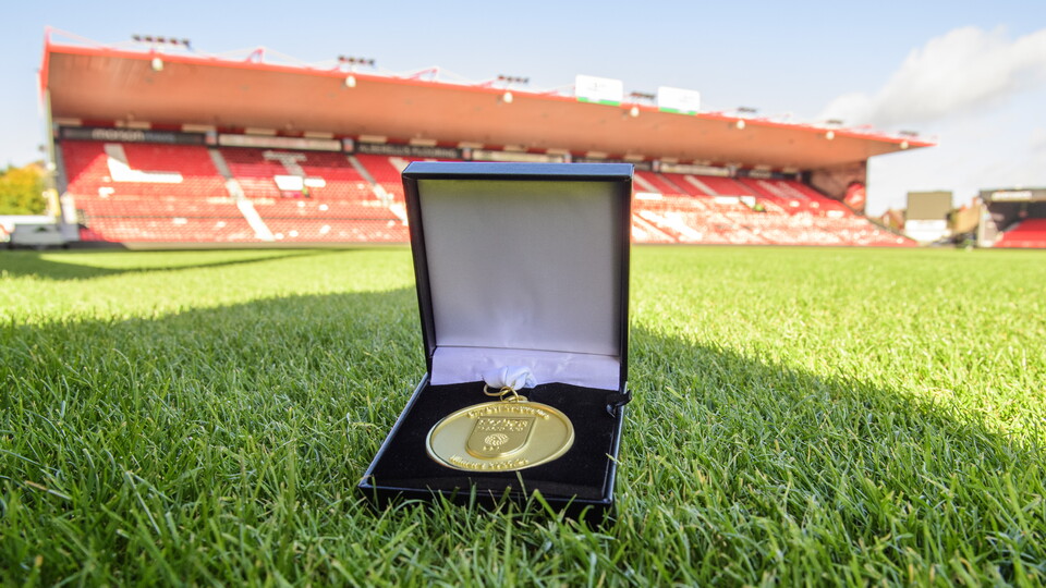 A League One medal in a presentation box on a grass pitch