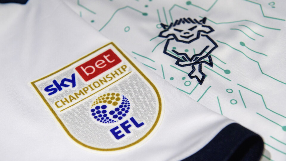 A close up of a Championship badge and the Lincoln City badge on a white shirt