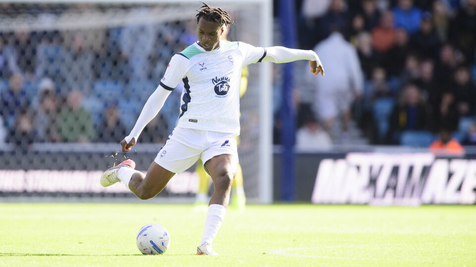 Deji Elerewe wearing a white kit kicks a football